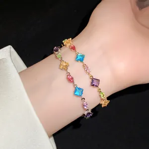 Macro view of colorful zircon rhombus and oval gemstone bracelets worn on a wrist