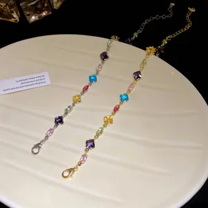 Close-up of elegant gold and silver bracelets with vibrant multi-colored zircon stones