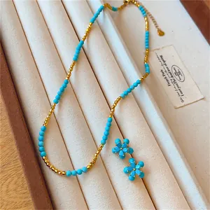 Vue détaillée de l'ensemble collier plaqué or 18 carats et boucles d'oreilles fleurs