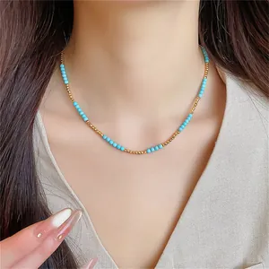 Gros plan d'un collier ras du cou en perles turquoise plaqué or 18 carats sur un mannequin
