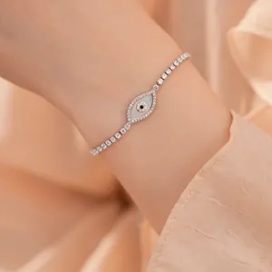 Close-up van een elegante evil eye armband met schelpinleg en zirkonia om een vrouwenpols