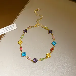 Detailed close-up of a gold-plated bracelet featuring vibrant multi-colored zirconia stones