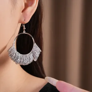 Elegante silberne Perlen-Creolen, getragen von einem Modell, zeigen das große Modedesign