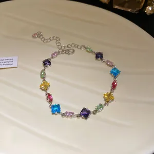 Close-up of elegant silver bracelet with multicolored rhombus and oval zircons