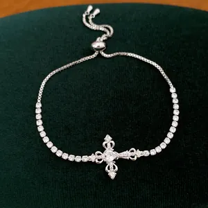 Gedetailleerde weergave van zilverkleurige kruisarmband met zirkonia en verstelbare sluiting