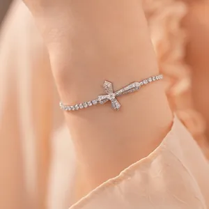 Elegante zilverkleurige kruisarmband met fonkelende zirkonia om de vrouwelijke pols
