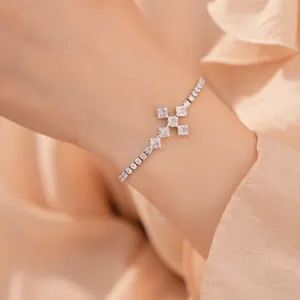 Detail van een elegante zilveren kruisarmband met sprankelende zirkonia-steentjes
