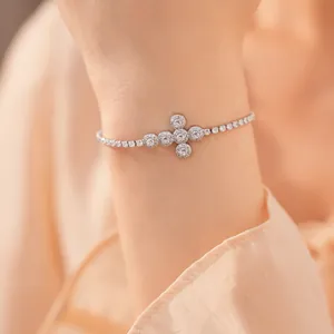 Elegant zilverkleurig armbandje met kruisvormige zirkonia-inlay om de pols van een model