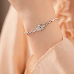 Close-up van een elegante zilveren evil eye armband met parelmoer en zirkonia's