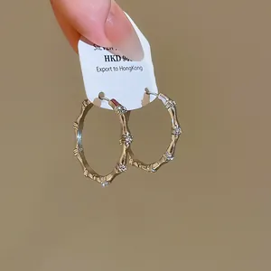 Close-up detail of vintage bamboo-style hoop earrings with pave zircon settings