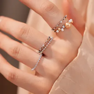 Nahaufnahme von 18k vergoldeten Perlen- und Zirkon-Ringen an einer Modelhand