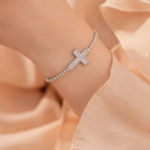 Gedetailleerd overzicht van een zilverkleurige kruisarmband met zirkonia steentjes