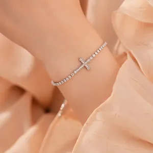 Detail van een elegante zilveren kruisarmband met schitterende zirkoniasteentjes