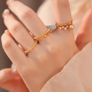 Makroaufnahme eines 18k vergoldeten Ring-Sets mit Perlen und Zirkonia-Steinen.