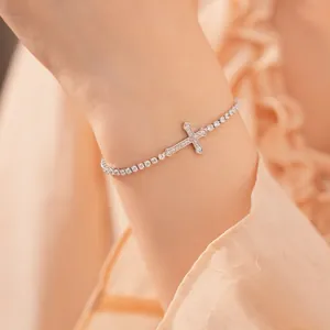 Close-up van een verfijnde zilveren kruis tennisarmband met fonkelende zirkonia