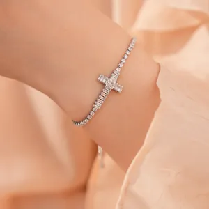 Elegante close-up van een sprankelende zilverkleurige zirkoon kruisarmband om een pols