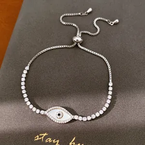 Detailweergave van zilverkleurige evil eye armband met witte schelp en zirkoniasteentjes