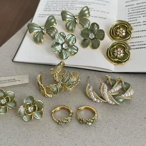 Vue détaillée de boucles d'oreilles vintage en émail vert avec papillons et fleurs