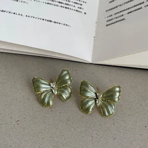 Vue détaillée de boucles d'oreilles papillon vert vintage plaquées or 14 carats avec cristal.