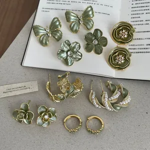 Vue détaillée de diverses boucles d'oreilles vintage vert sauge avec papillons et fleurs