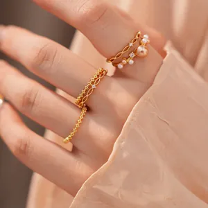 Detailansicht eines 18k vergoldeten Ring-Sets mit Zirkon-Akzenten und Perlen an einer Hand