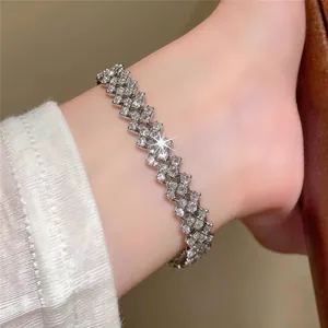 Close-up view of silver-toned zigzag bracelet with shimmering clear stones on wrist.