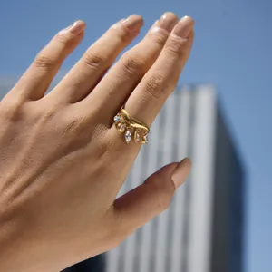 Detailansicht eines 18 Karat vergoldeten Wellenrings mit funkelnden Zirkonia-Anhängern