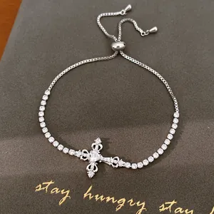 Gedetailleerd overzicht van een zilveren kruisarmband met glinsterende zirkonia