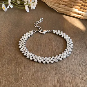 Close-up detail of a silver bracelet with three rows of round sparkling rhinestones