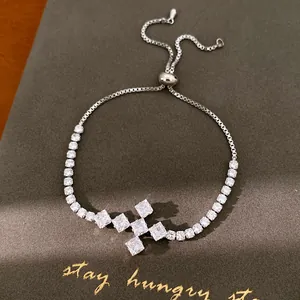 Detailopname van een zilveren zirkoon kruisarmband op een hoogwaardige donkere achtergrond