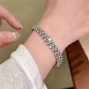 Close-up detail of a sparkling silver three-row rhinestone bracelet worn on a wrist