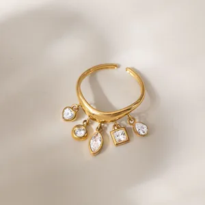 Nahaufnahme eines 18k vergoldeten Rings mit fünf geometrischen Zirkonia-Anhängern.