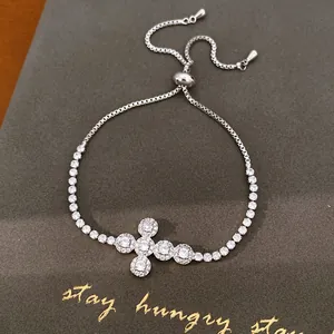 Detailweergave van een verstelbare zilveren kruisarmband met fonkelende zirkonia's.