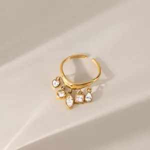 Detailaufnahme vergoldeter Edelstahl Wellenring mit geometrischen Zirkonia Quastenanhängern