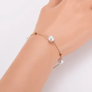 Detailaufnahme eines minimalistischen Edelstahlarmbands mit eleganten Perlen und Gold