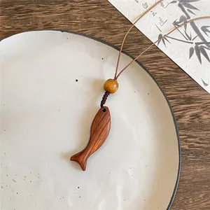 Minimalistische Fisch-Halskette aus Holz mit Zen-Ästhetik und einem braunen Kordel