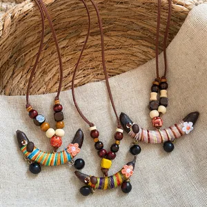 Gros plan de colliers ethniques faits main avec pendentifs colorés en forme de pois