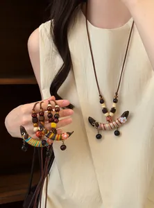 Détail d'un collier ethnique en perles de bois avec pendentif en forme de croissant