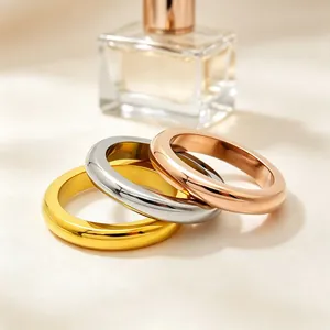 Close-up of three polished stainless steel stackable rings in gold, silver, and rose gold