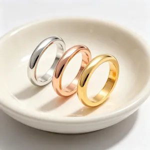 Close-up of polished stainless steel rings in gold, silver, and rose gold finishes.