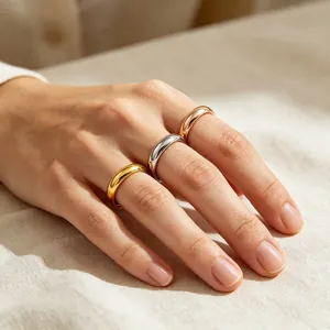 Close-up of minimalist gold, silver, and rose gold polished stainless steel band rings