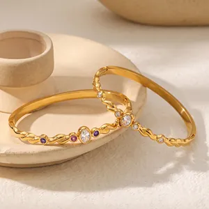Détail de joncs en acier inoxydable plaqué or 18k avec zircons colorés vibrants.