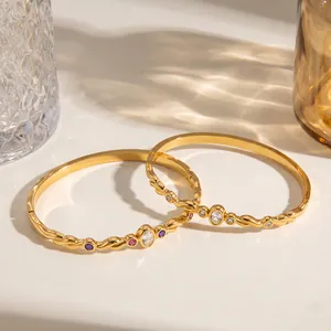 Détail de bracelets élégants en acier inoxydable doré avec des pierres en zircone