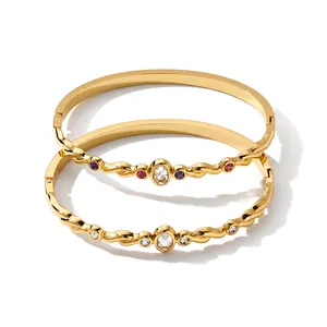 Gros plan sur des bracelets en acier inoxydable plaqué or 18k ornés de zircons colorés.