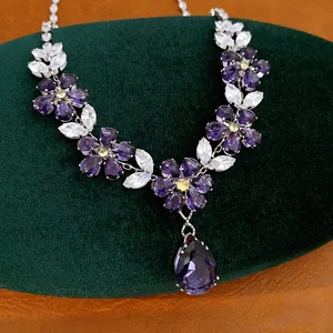 Makro-Detail einer Vintage-Blumenkette mit lila Zirkoniasteinen und Tropfenanhänger