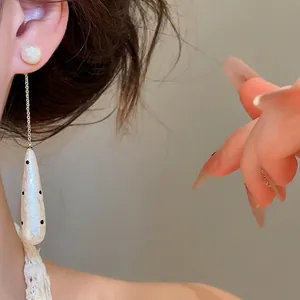 Eleganti orecchini a goccia retrò con pois neri e finitura perlata sulla modella asiatica.