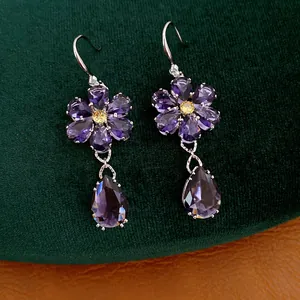Detailansicht der Vintage-Ohrringe mit lila Zirkonia-Blumen und Wassertropfen-Anhängern.
