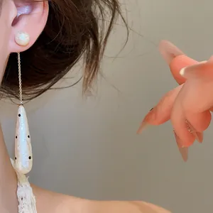 Close-up of vintage polka dot waterdrop pearl earring with delicate chain