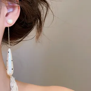 Close-up detail shot of elegant vintage polka dot waterdrop pearl long drop earrings for women