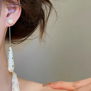 Detailed view of elegant retro polka dot waterdrop pearl drop earrings worn by a model